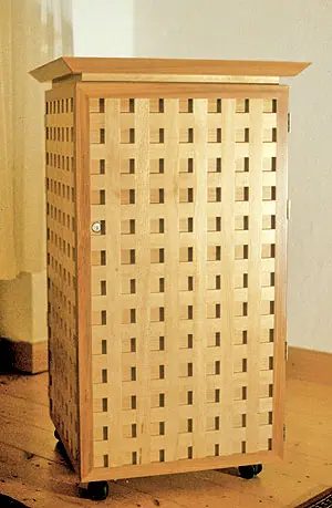 Hoher Schrank aus massiver Buche mit Gitterfront aus Holzleisten, auf Rollen