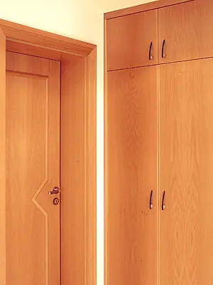 Holztür neben einem raumhohen Einbauschrank in gleichem Holzton